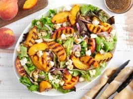 Overhead view of a grilled peach salad on a platter.