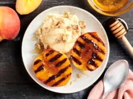 Overhead view of a bowl of grilled peaches and ice cream.
