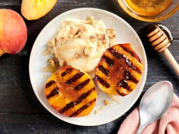 Overhead view of a bowl of grilled peaches and ice cream.