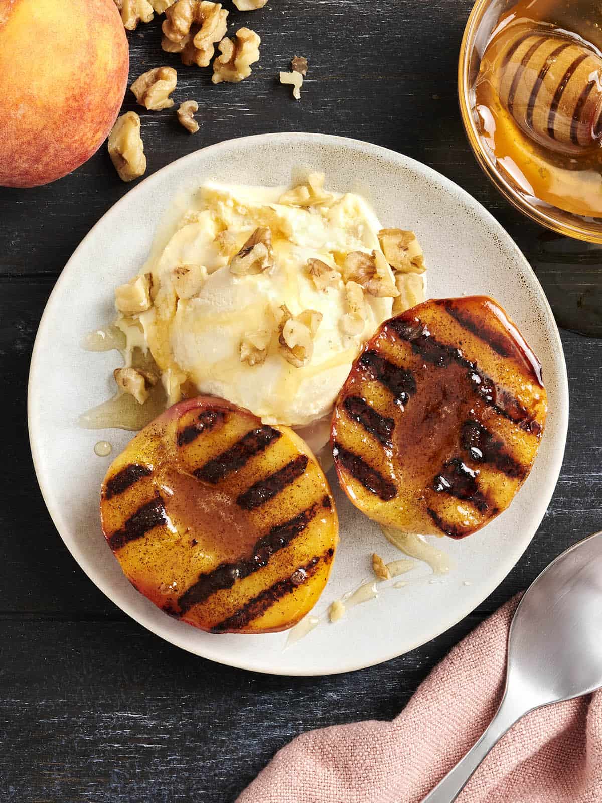 Overhead view of a bowl of grilled peaches and cream.