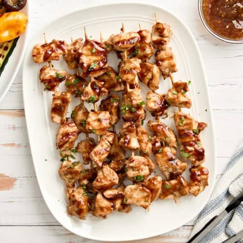 Overhead view of grilled teriyaki skewers on a platter.