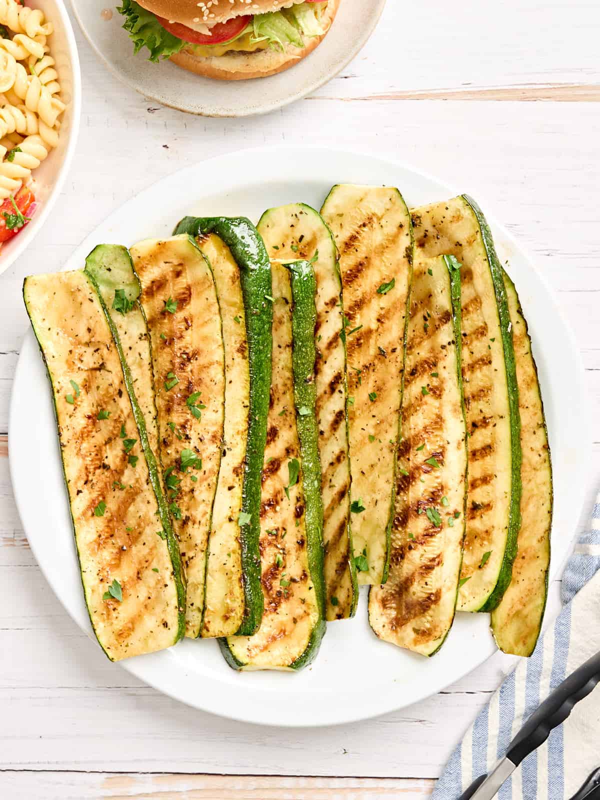 Overhead view of grilled zucchini slices on a plate.