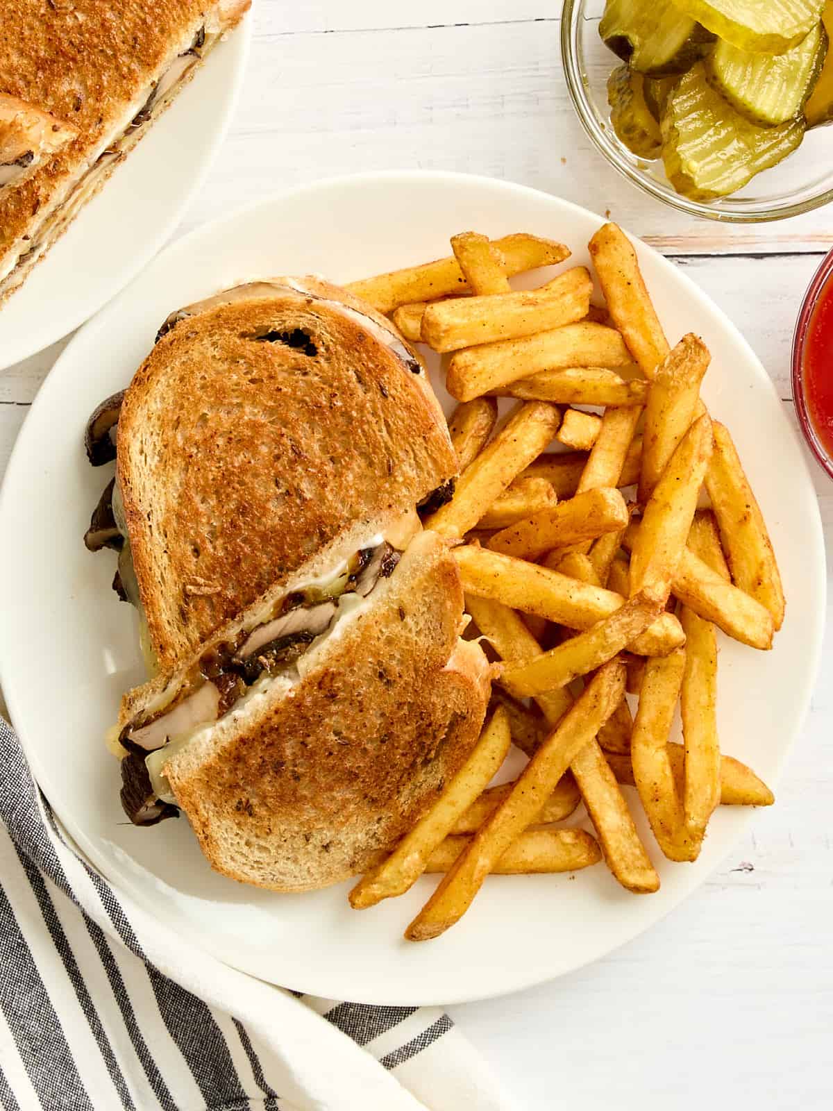 Overhead view of a mushroom patty melt and fries on a plate.