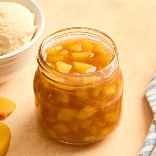 Side view of homemade peach sauce in a glass jar.