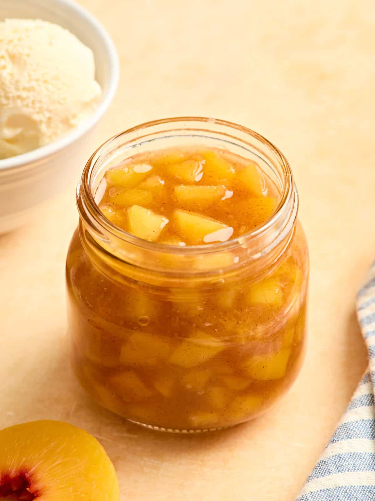 Side view of homemade peach sauce in a glass jar.