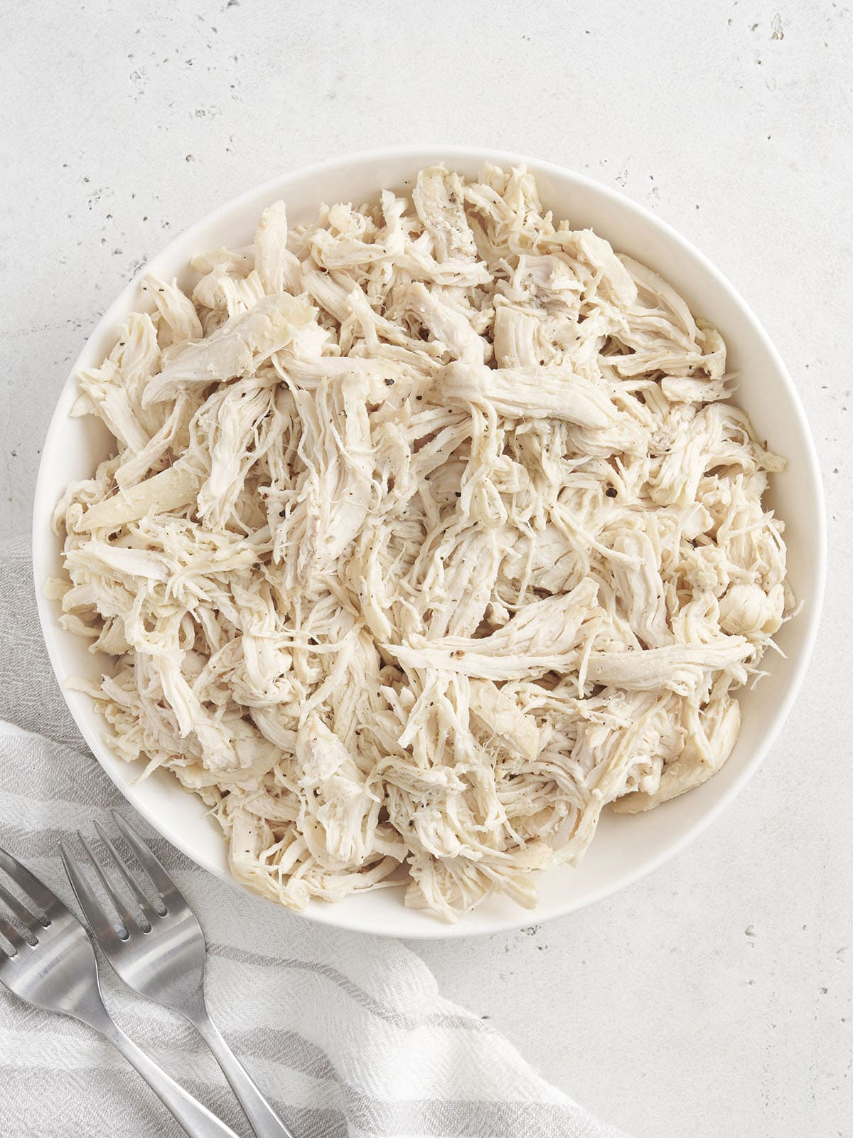 Overhead view of a bowl of shredded chicken.