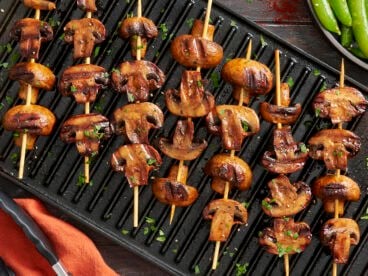 Overhead view of smoky grilled mushroom kebabs on a grill.