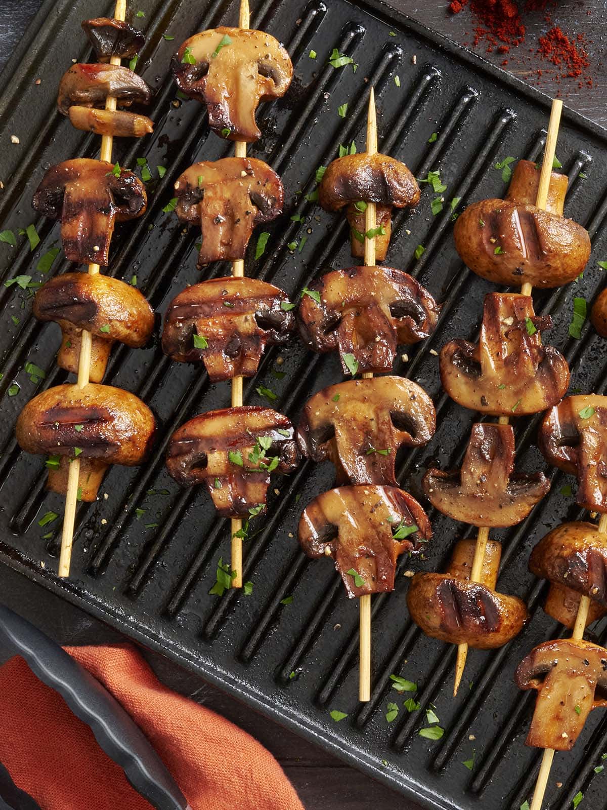 Overhead view of smoky grilled mushroom kebabs on a grill.