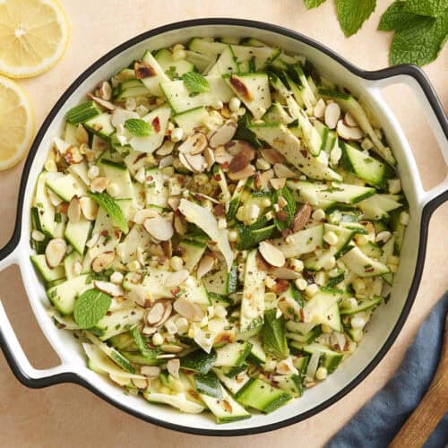 Overhead view of a bowl of zucchini, corn and toasted almond salad.