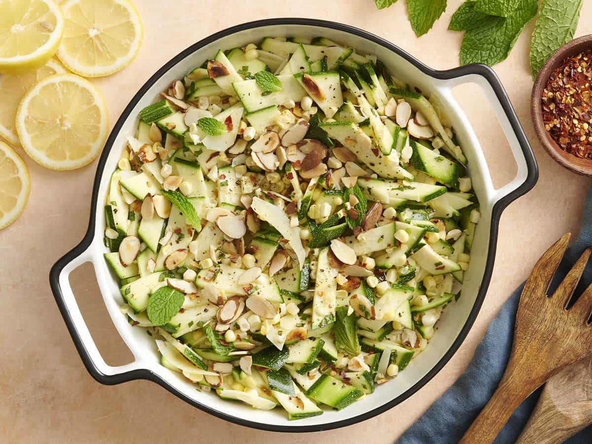 Overhead view of a bowl of zucchini, corn and toasted almond salad.