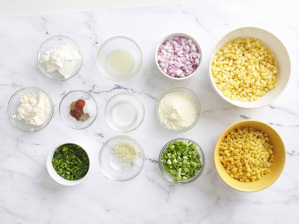 The ingredients to make a street corn pasta salad in a bowl.