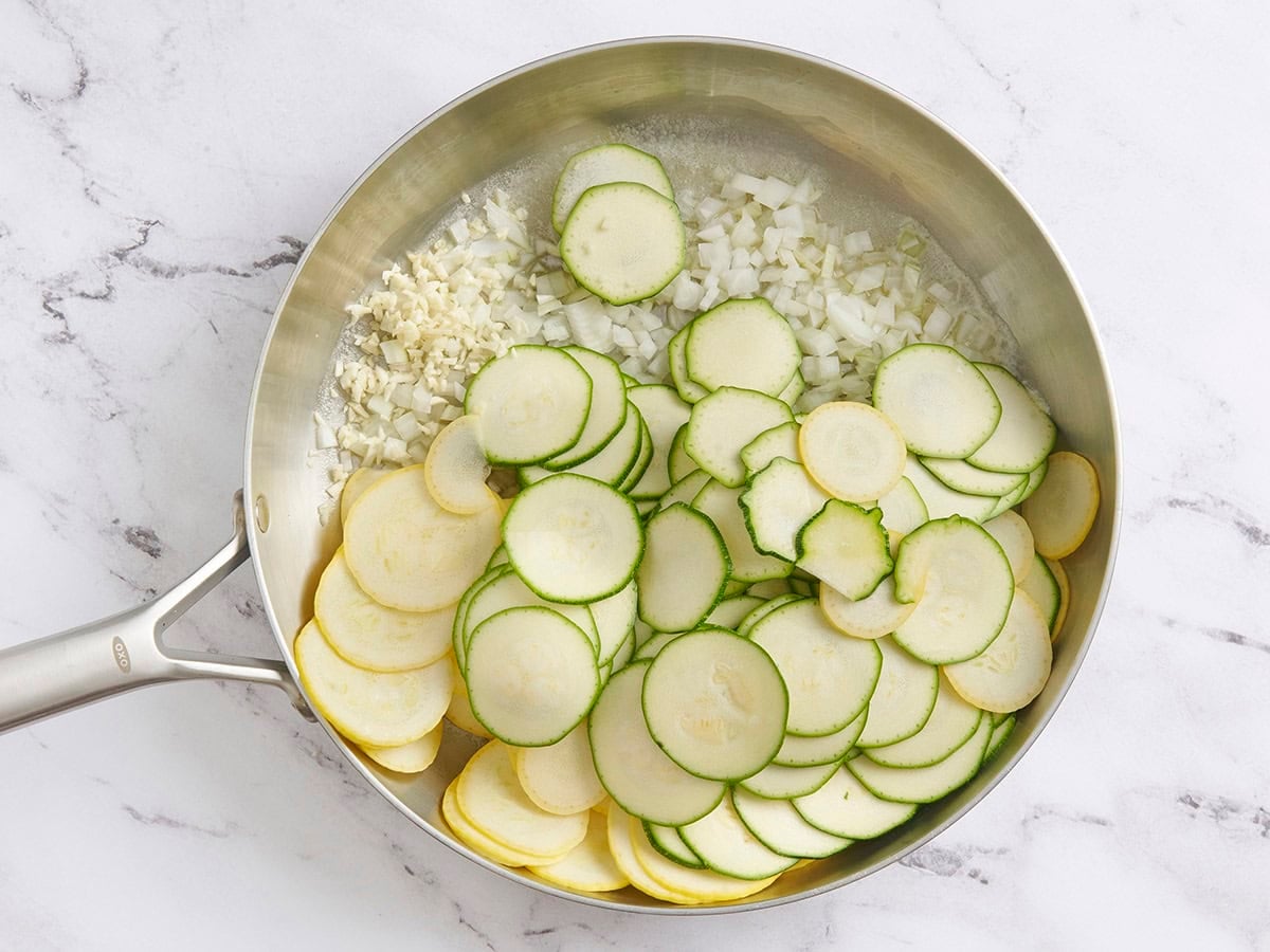 Zucchini, onion, and yellow squash in a skillet.