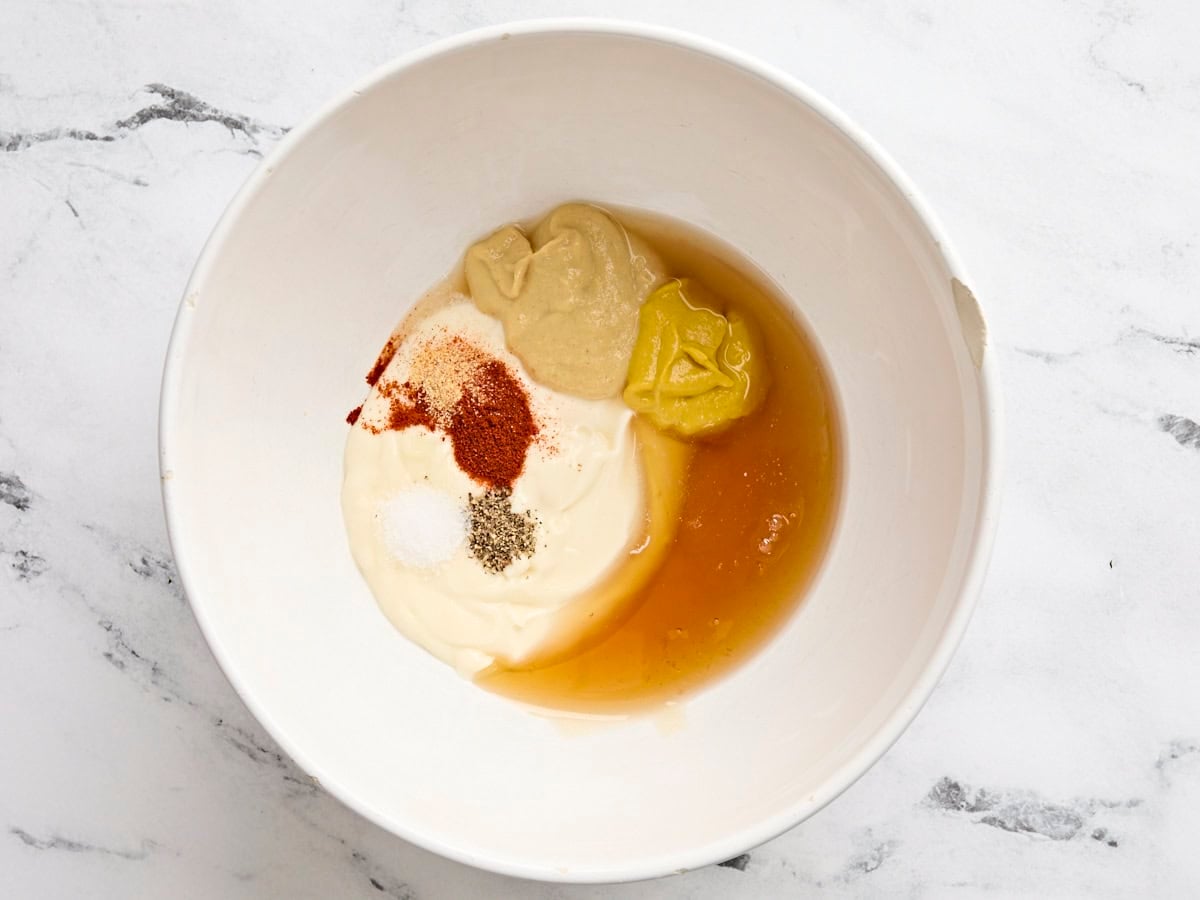 Mayo, mustard, honey, apple cider vinegar, and seasonings in a bowl.