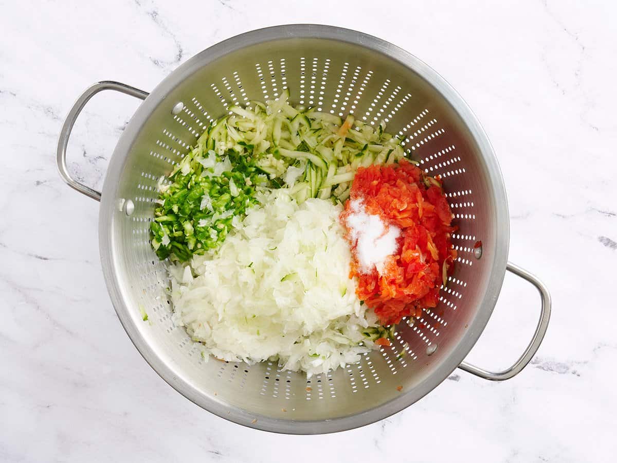 The ingredients for zucchini relish in a colander.