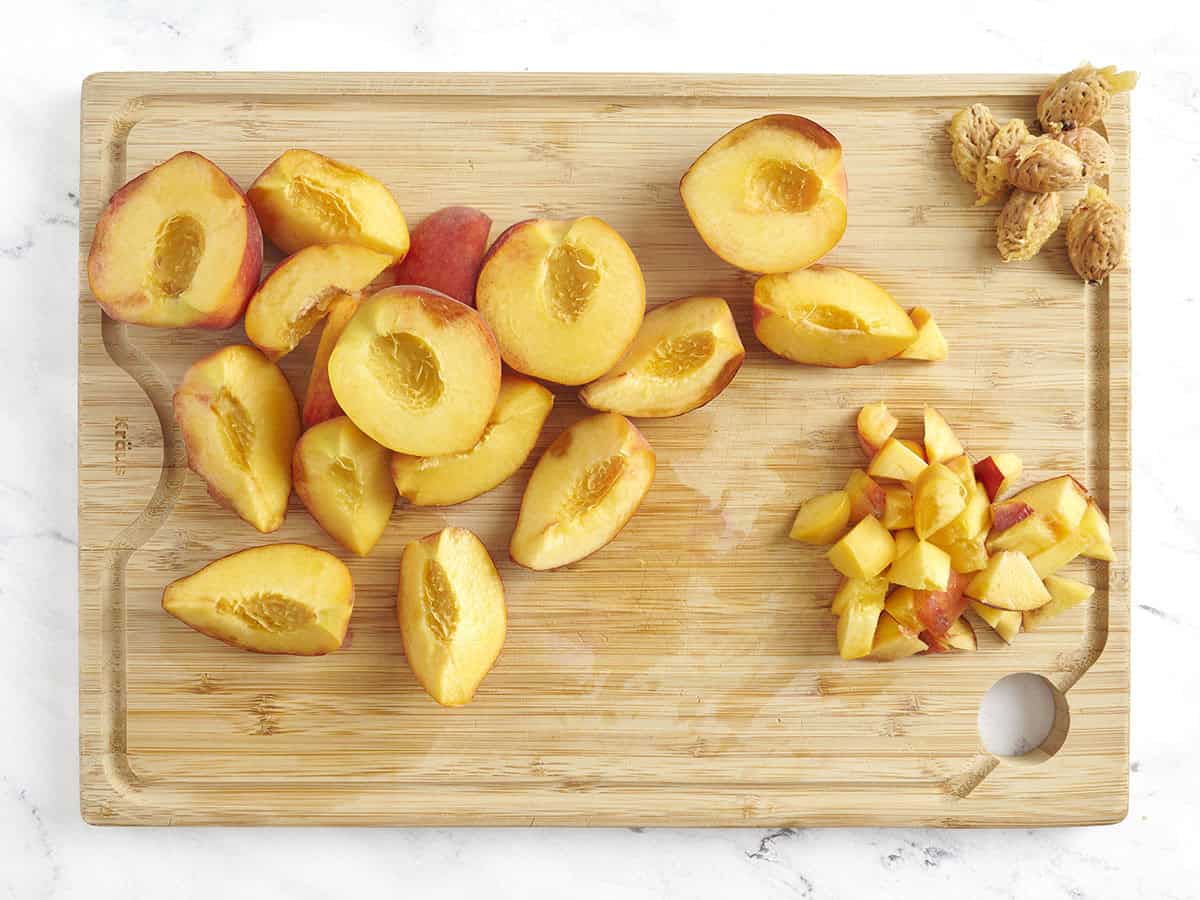 Fresh peaches cut into large slices on a cutting board.