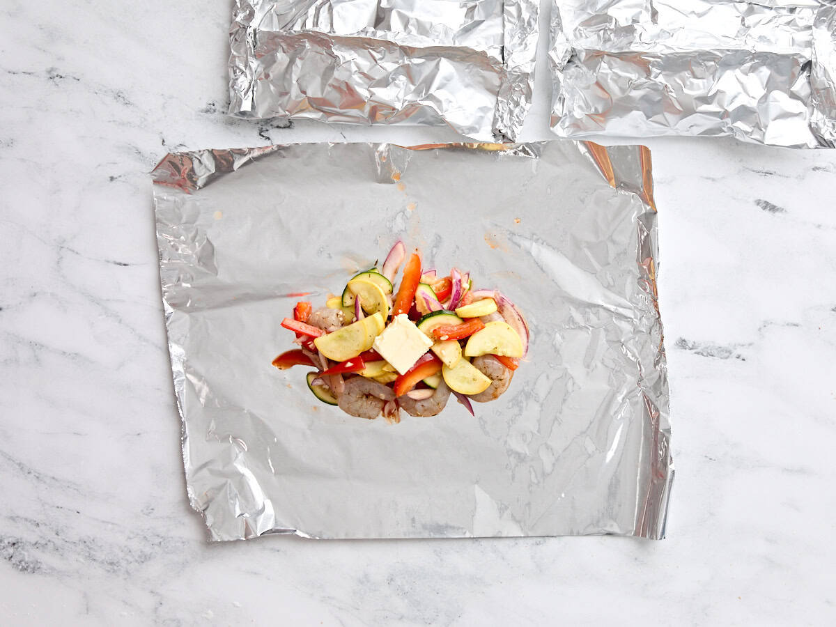 Shrimp and vegetable mixture on a square of foil.