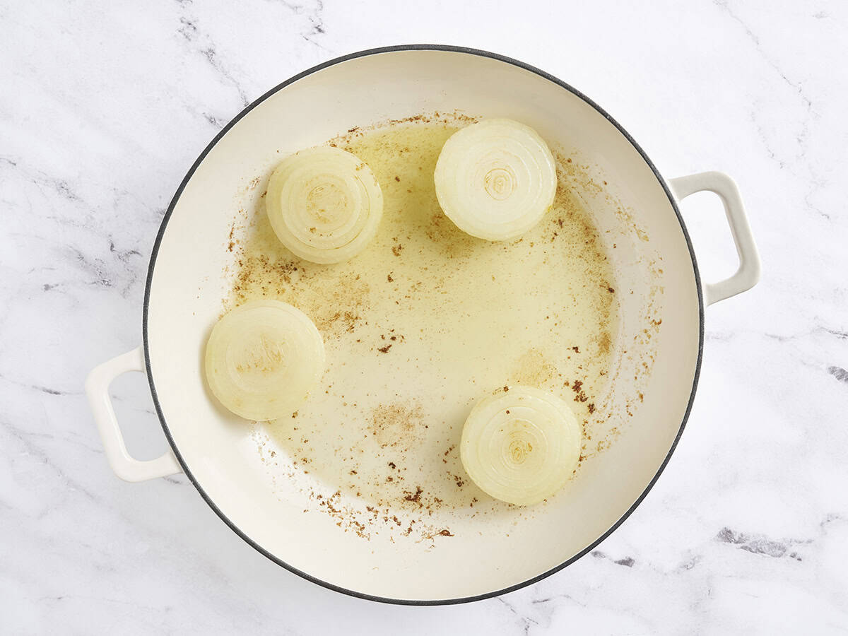 Onion halves browning in a skillet.