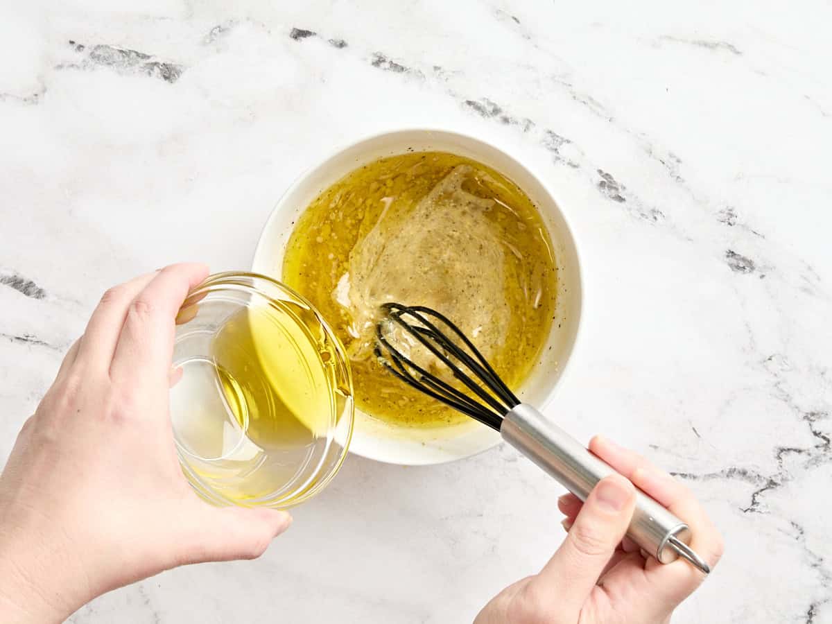 Oil being whisked into the ingredients for a lemon vinaigrette.