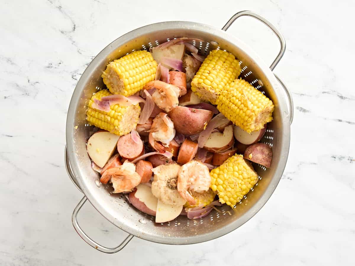 A shrimp boil in a pot with the water drained.