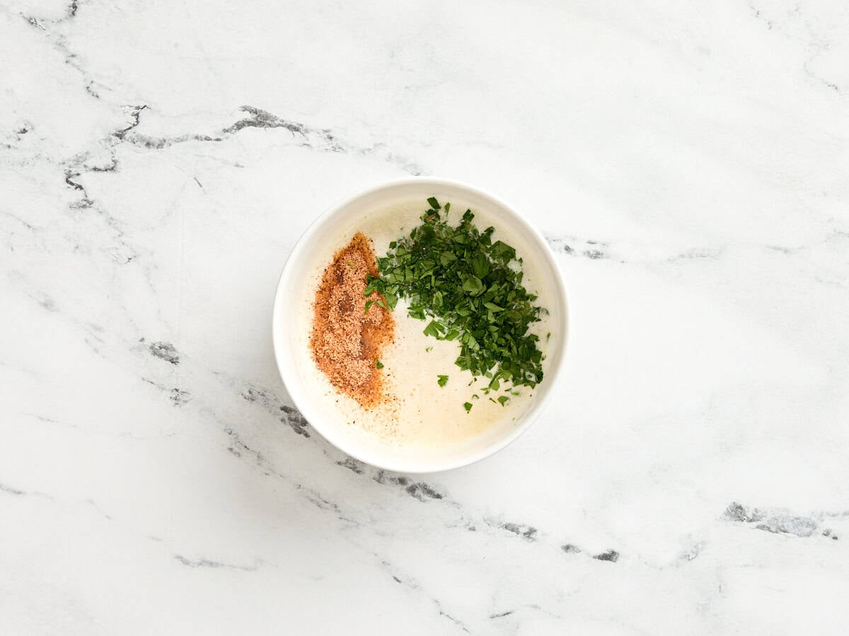 Cajun seasoning and fresh parsley added to melted butter.