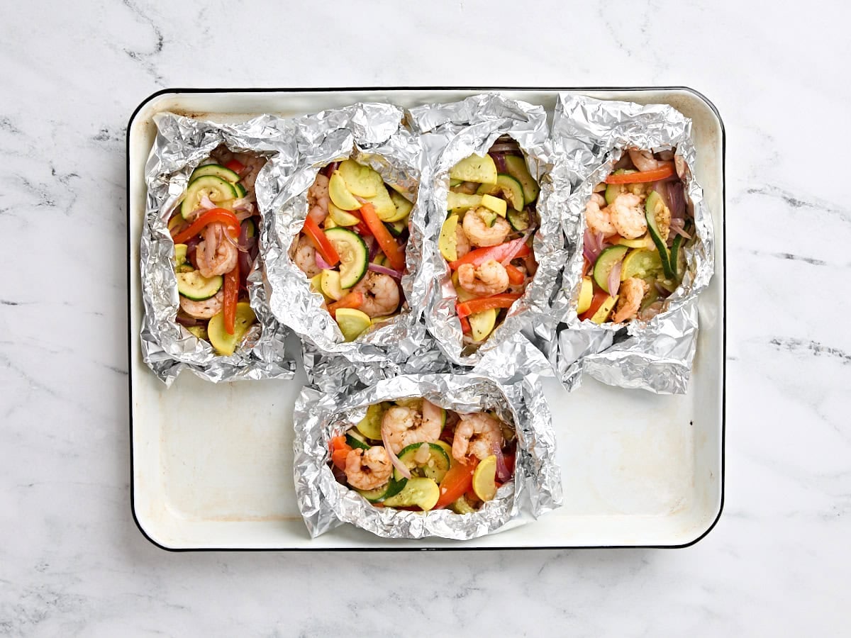 Finished grilled shrimp and vegetable foil packets.