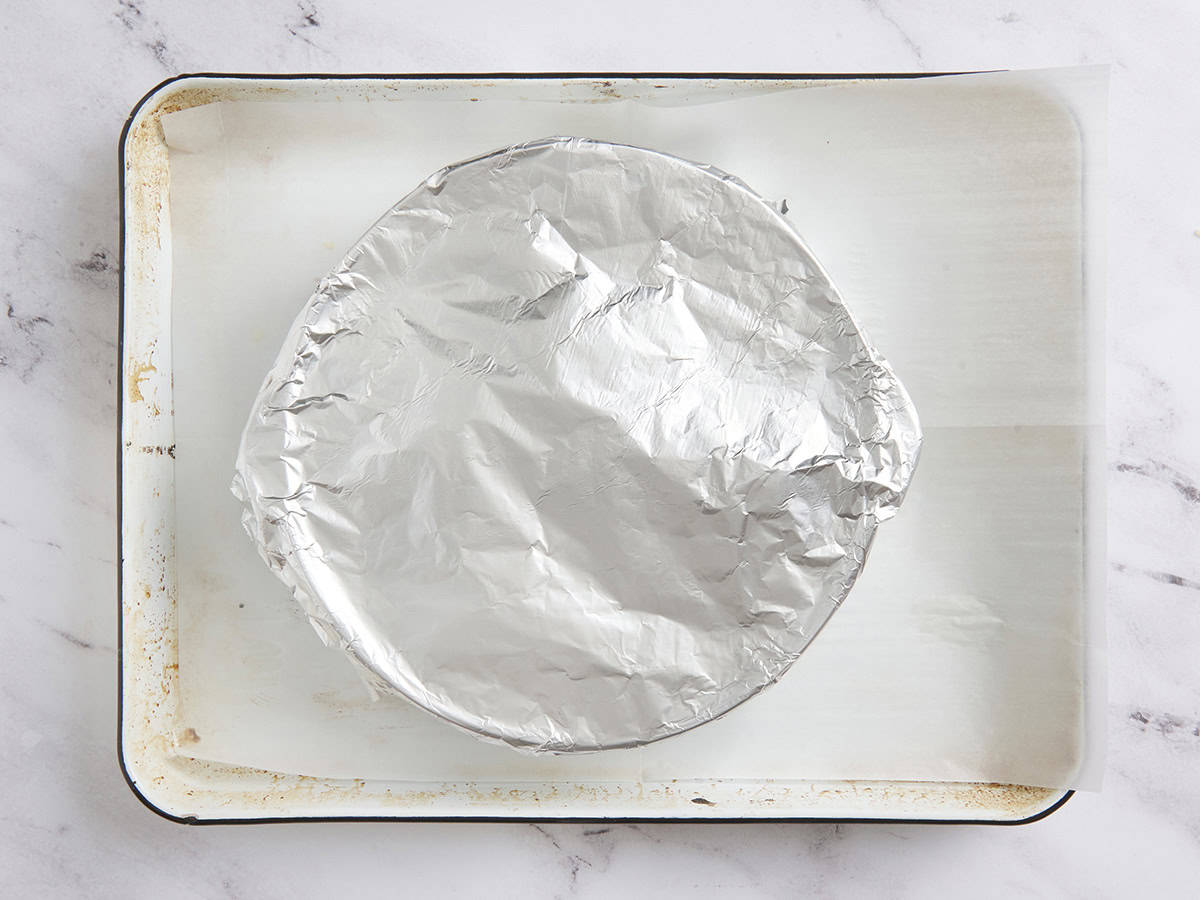 A pie dish covered with foil.