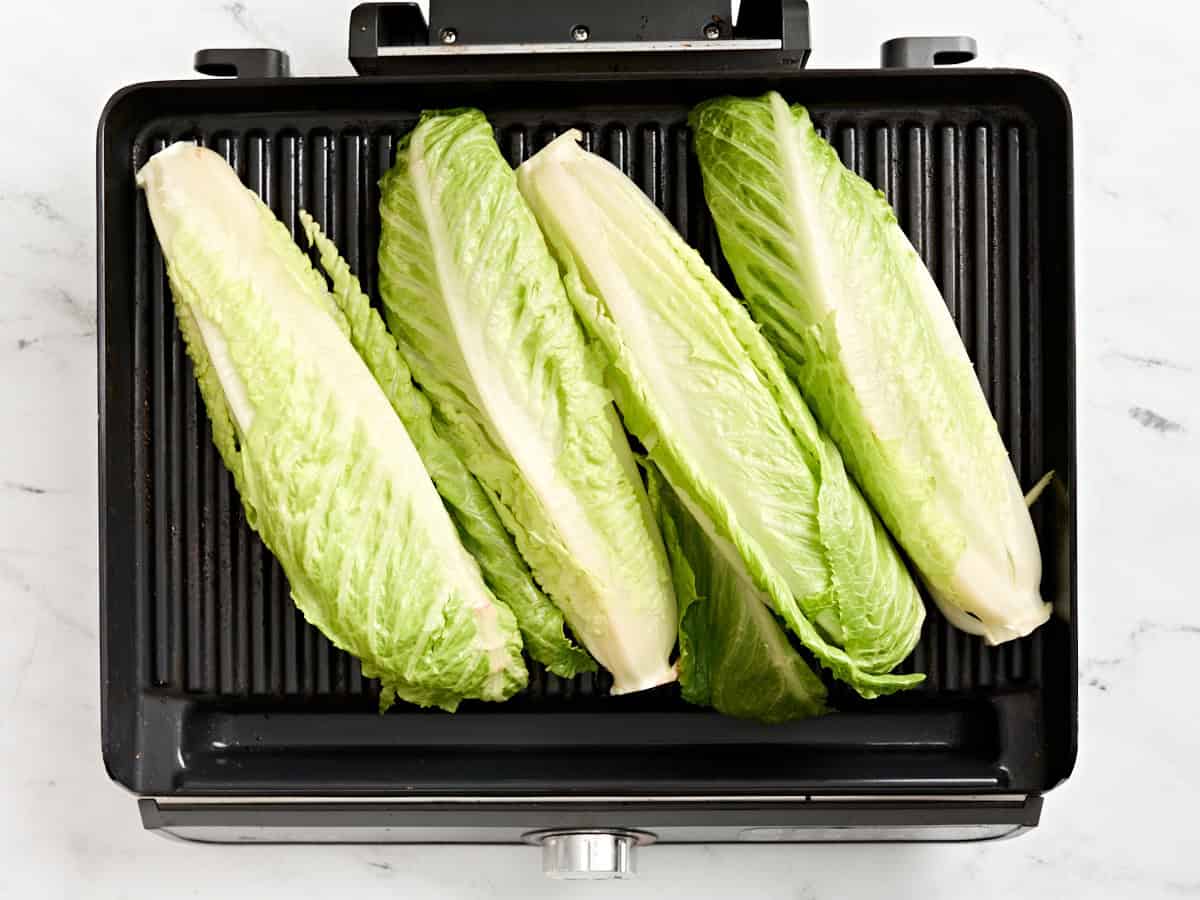 Romaine hearts grilling on a grill.
