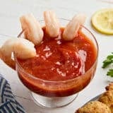 Side view of seafood sauce in a bowl with shrimp.