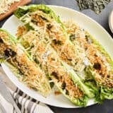 Overhead view of grilled romaine Caesar salad on a serving platter.