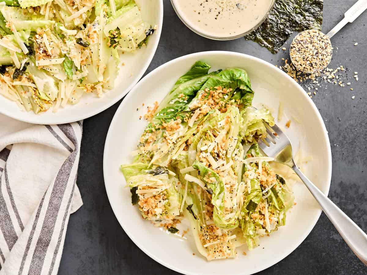 Overhead view of a grilled ceasar salad in a bowl with a fork.