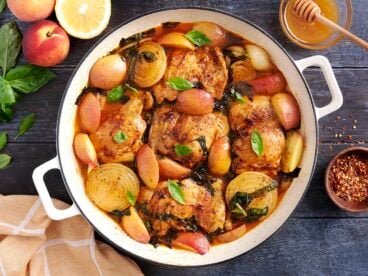 Overhead view of savory braised peach chicken in a skillet.