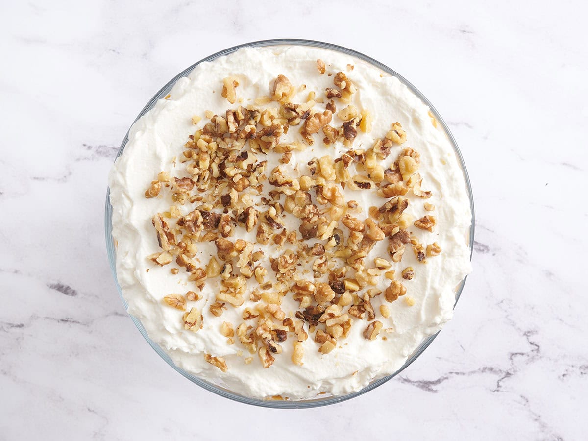 A homemade pumpkin trifle topped with whipped cream and walnuts.