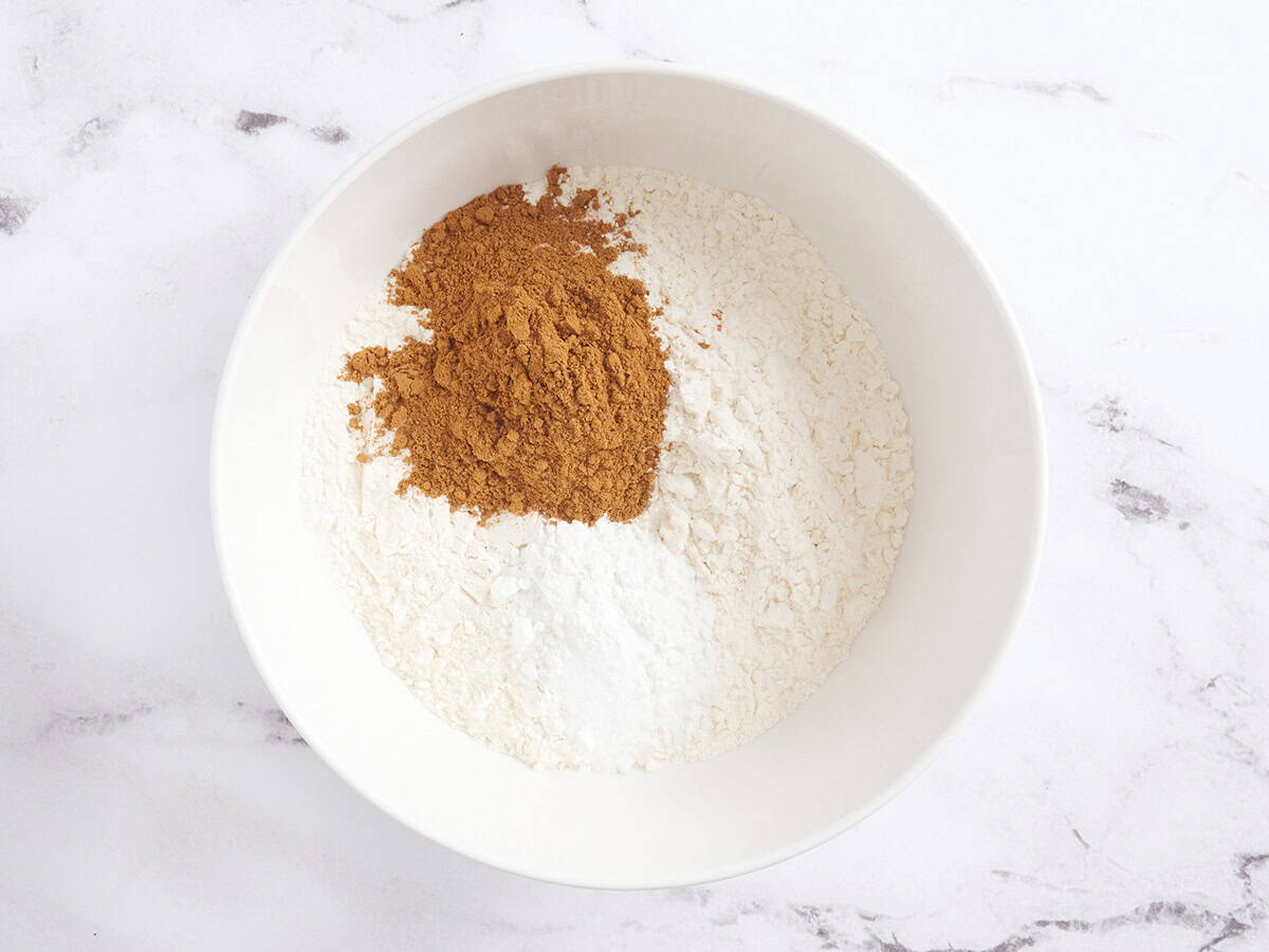 Baking powder, baking soda, flour, and spices in a mixing bowl.
