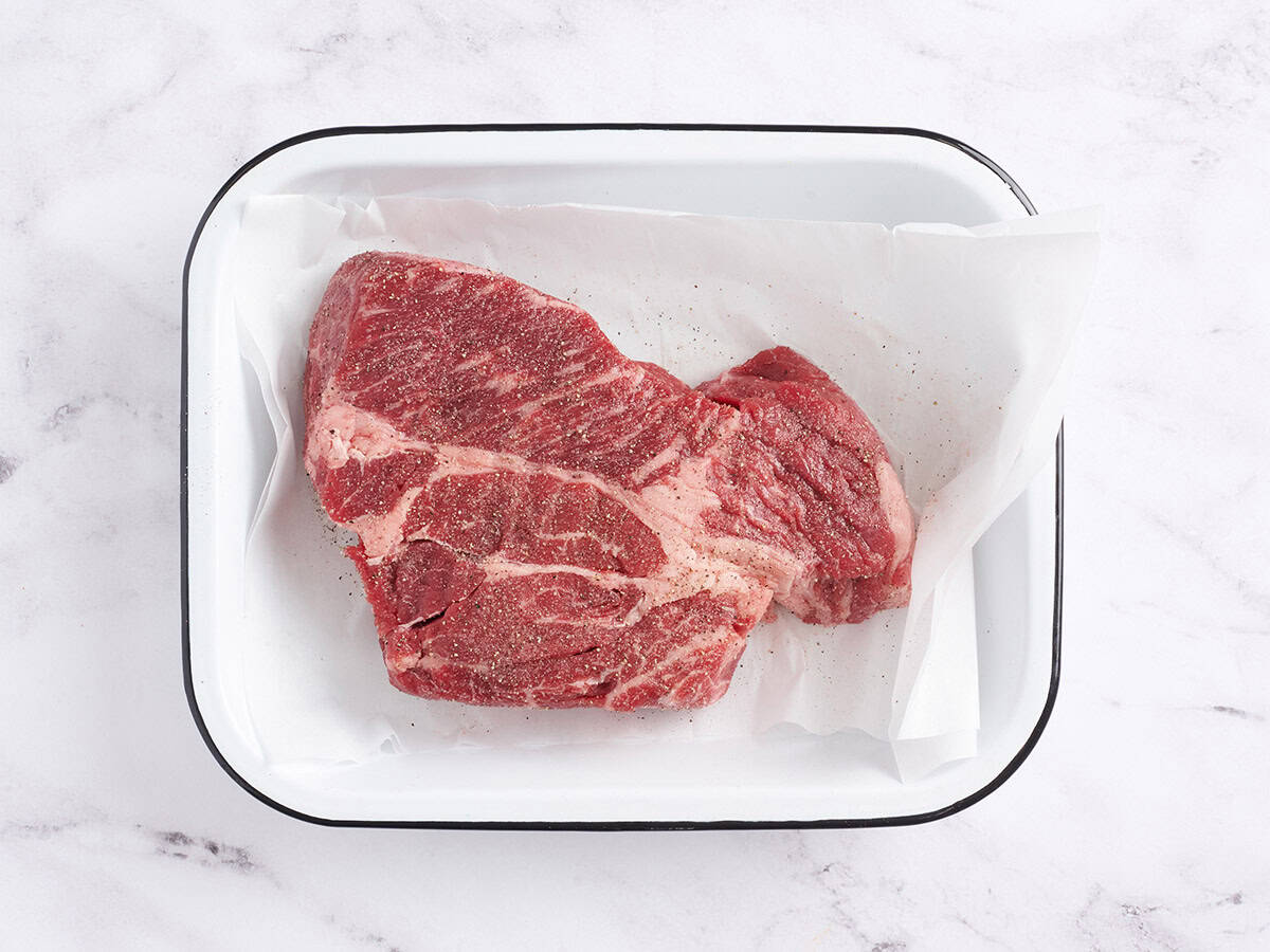 A chuck roast topped with salt and pepper