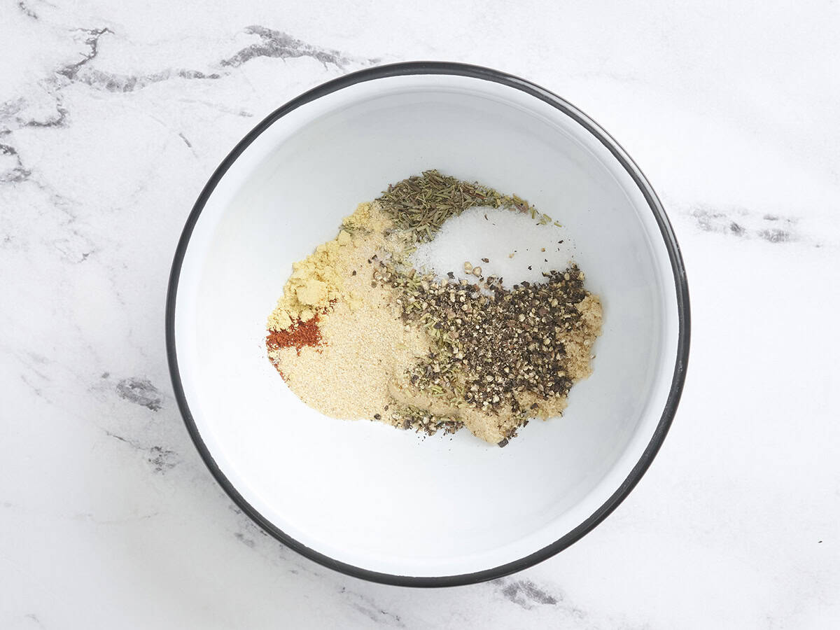Sugar, salt, pepper, and dried herbs in a mixing bowl to make a dry steak rub for grilled sirloin tender steaks.