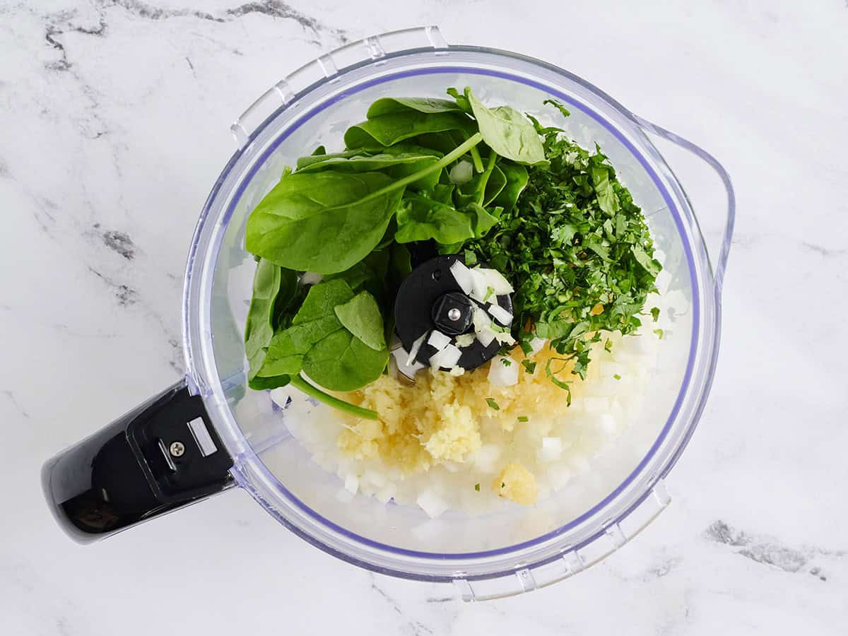Spinach, onion, garlic, and ginger in a food processor.