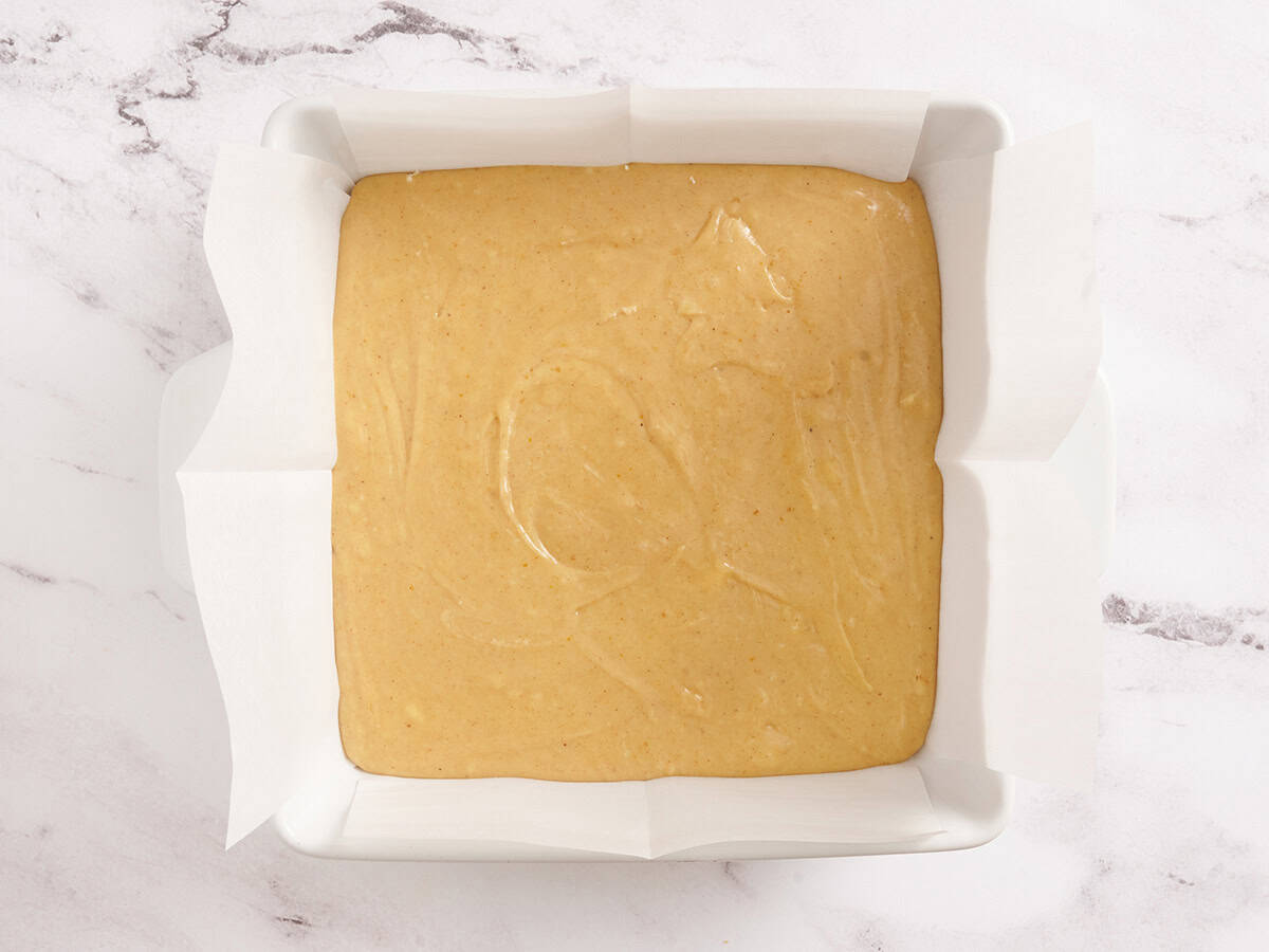 Pumpkin spice fudge in a parchment lined baking dish.