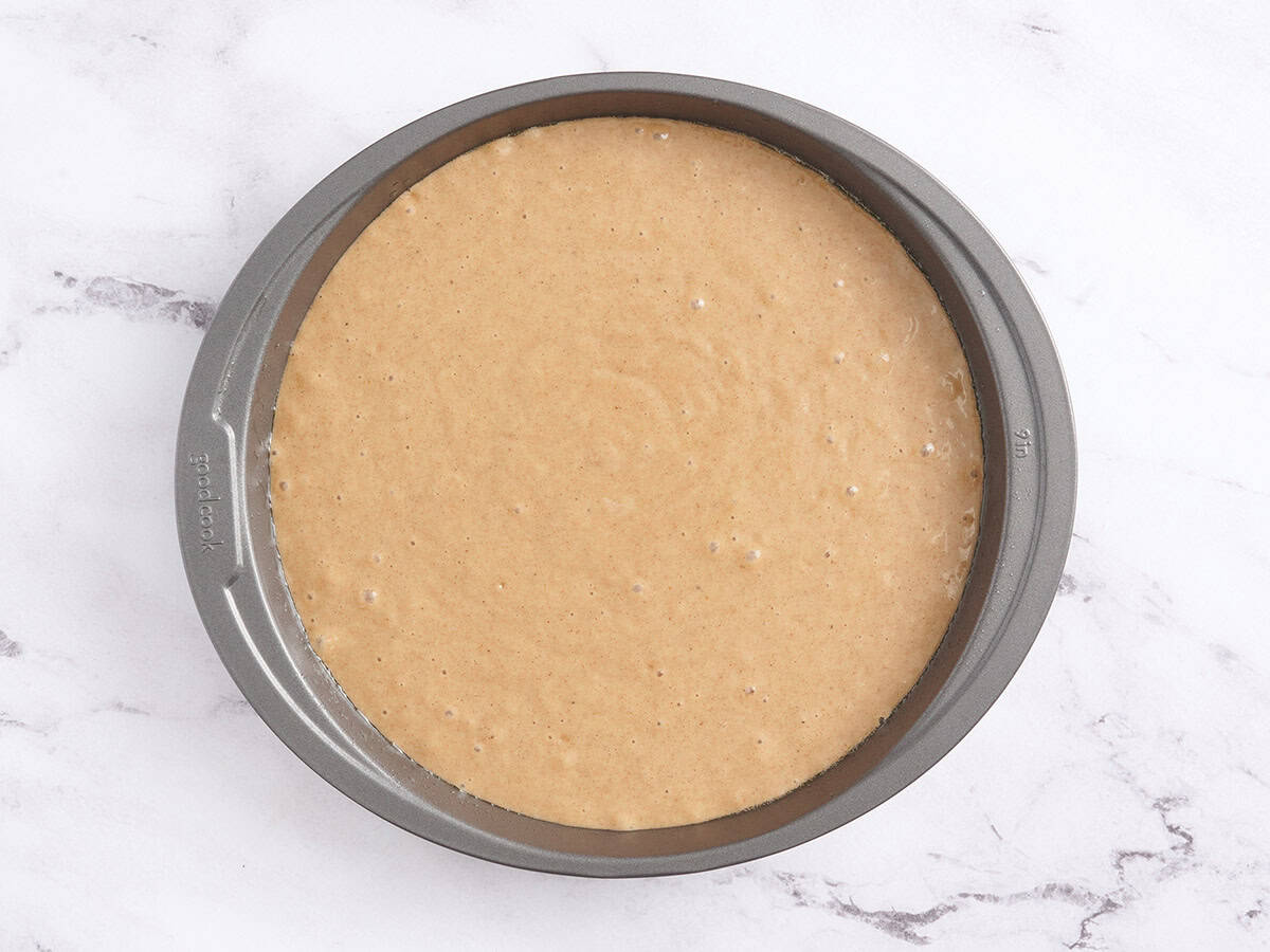 Spiced cake batter poured into a cake pan.