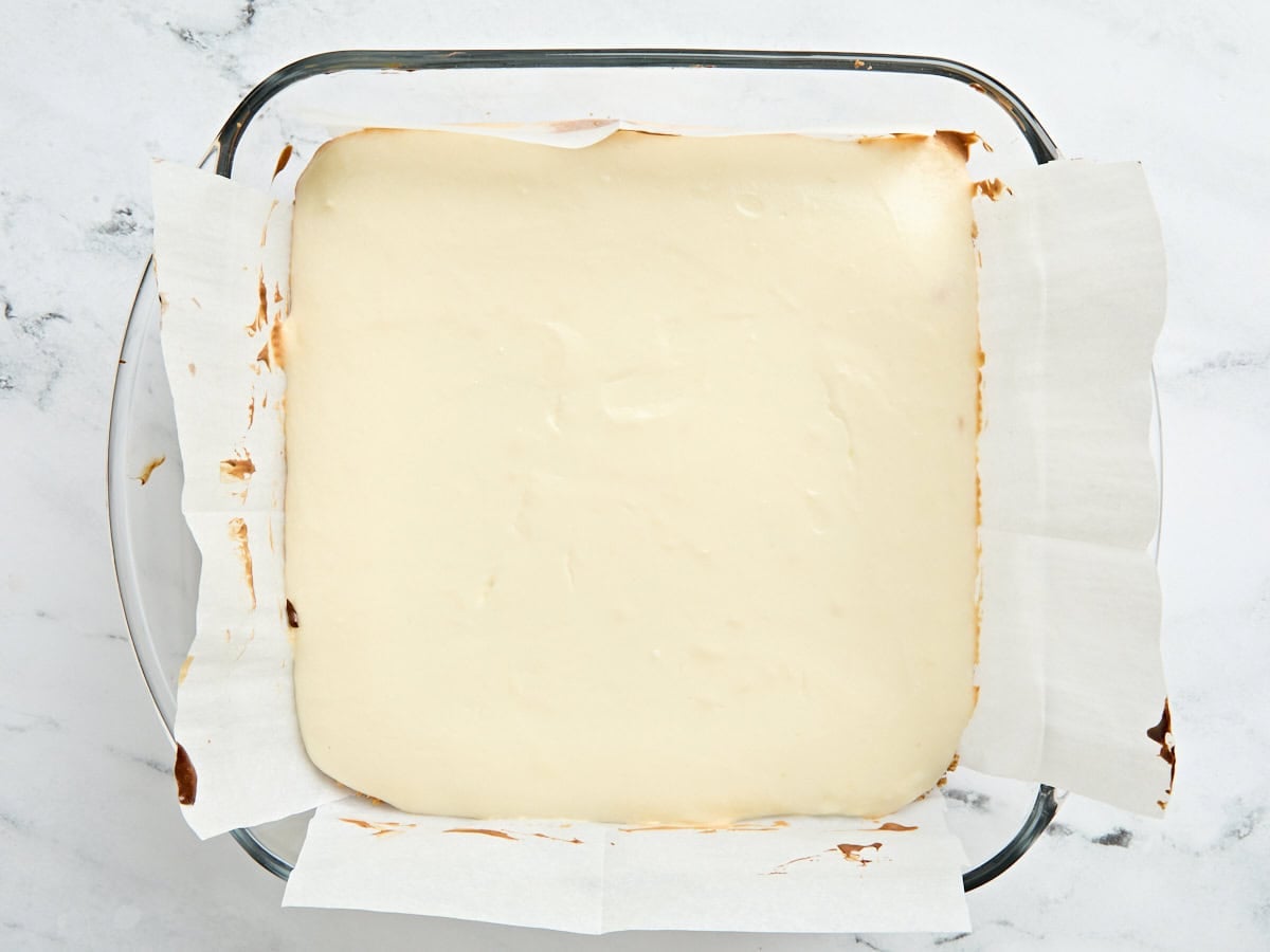 Baked cheesecake bars in a baking dish.