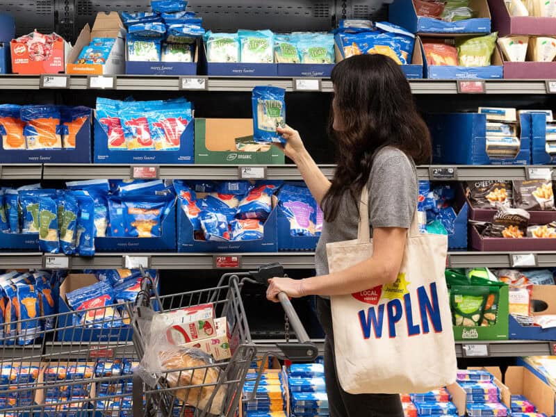 woman shopping in the cheese aisle at a grocery store