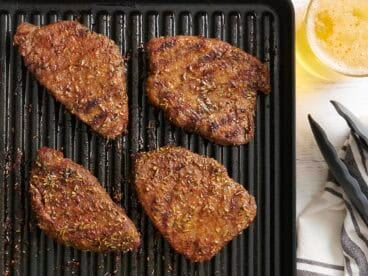 Overhead view of grilled sirloin tender steaks on a grill.