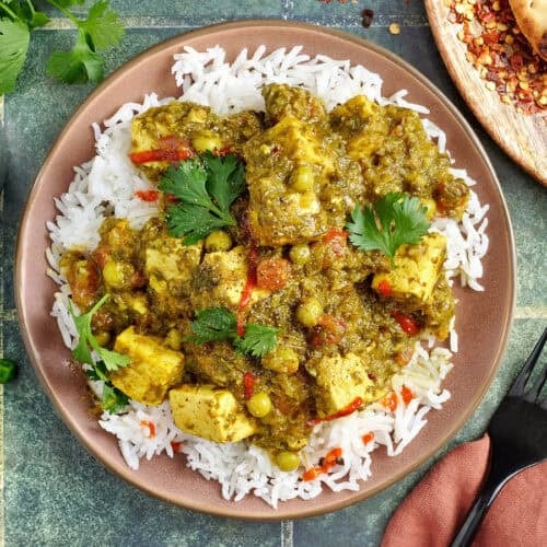 Overhead view of a vegan tofu curry on a plate with white rice.