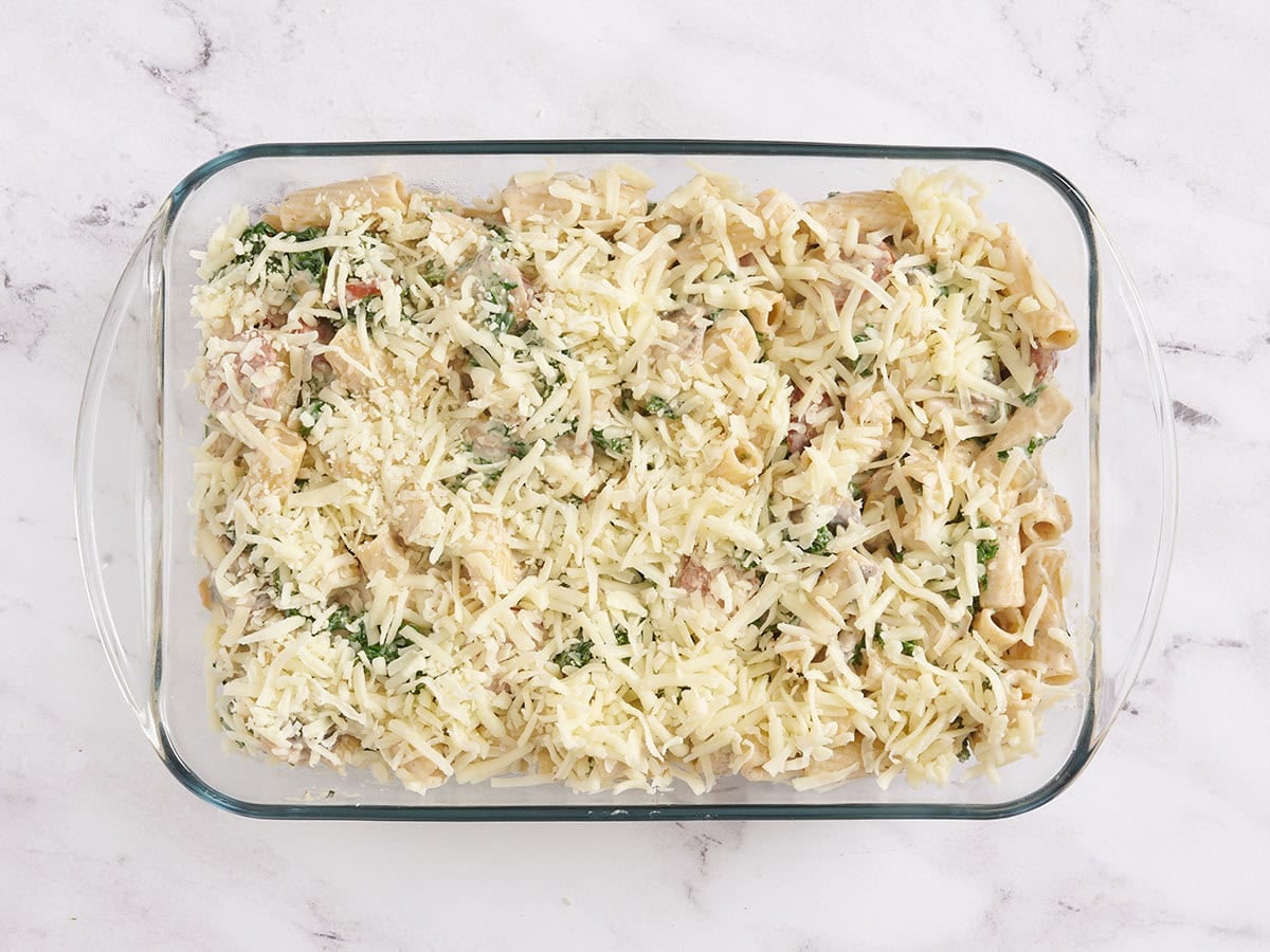 Turkey sausage and kale casserole in a baking dish topped with cheese.