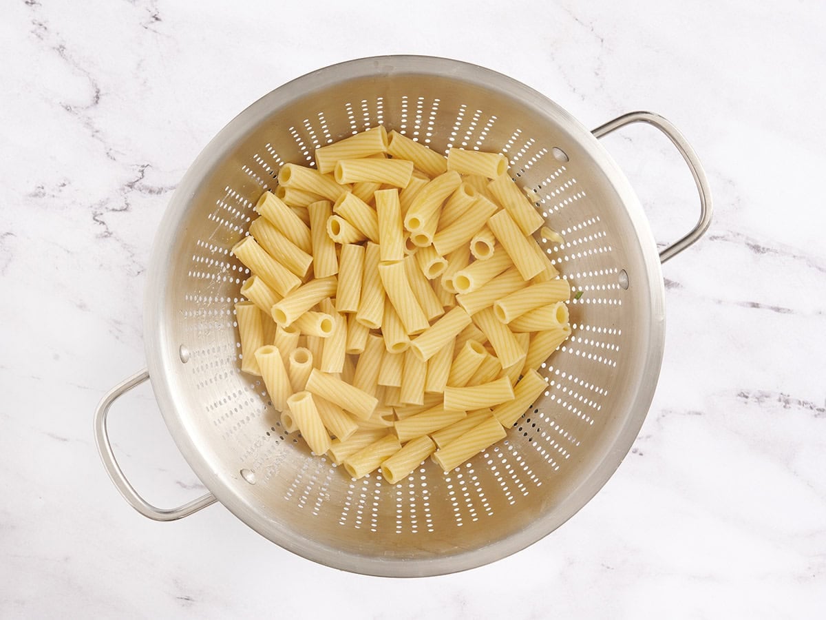Cooked rigatoni pasta in a colander.