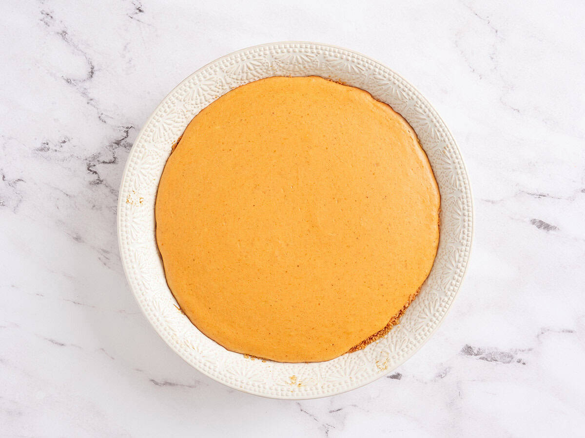 Baked pumpkin cheesecake in a pie dish.