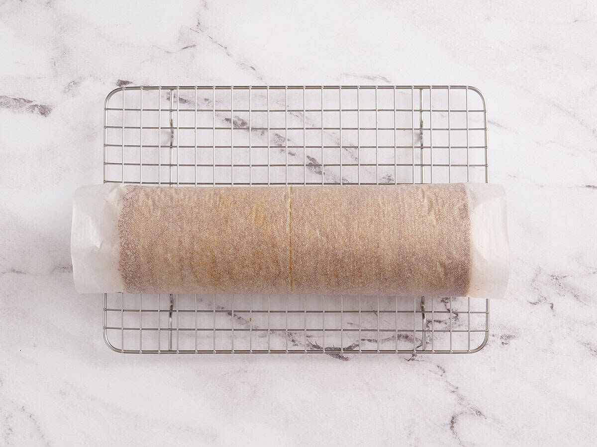 rolled pumpkin roll cooling on a wire rack