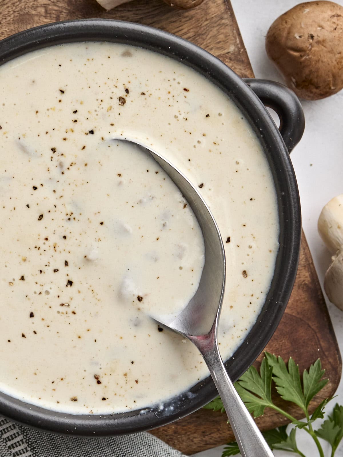 Overhead view of a bowl of cream of mushroom soup with a spoon.