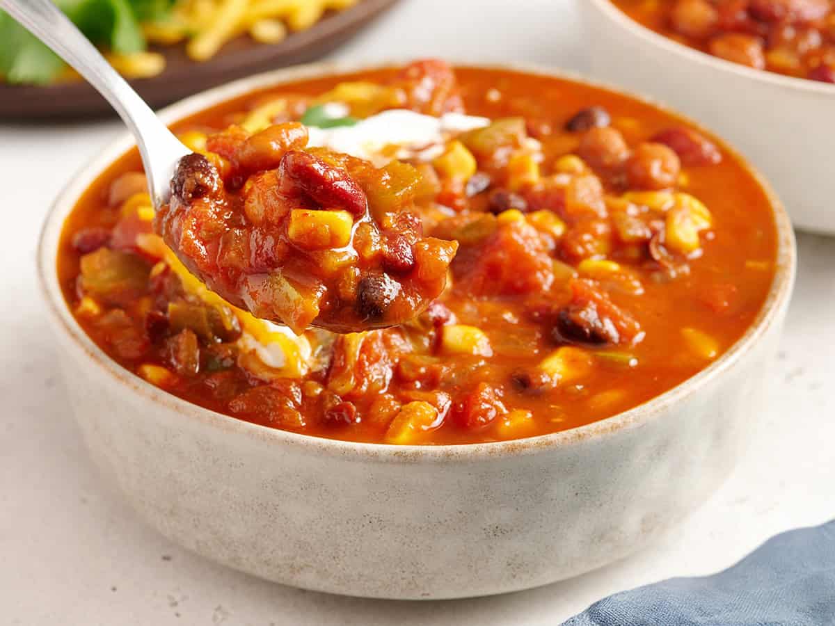 vegetarian chili in a bowl being lifted out with a spoon