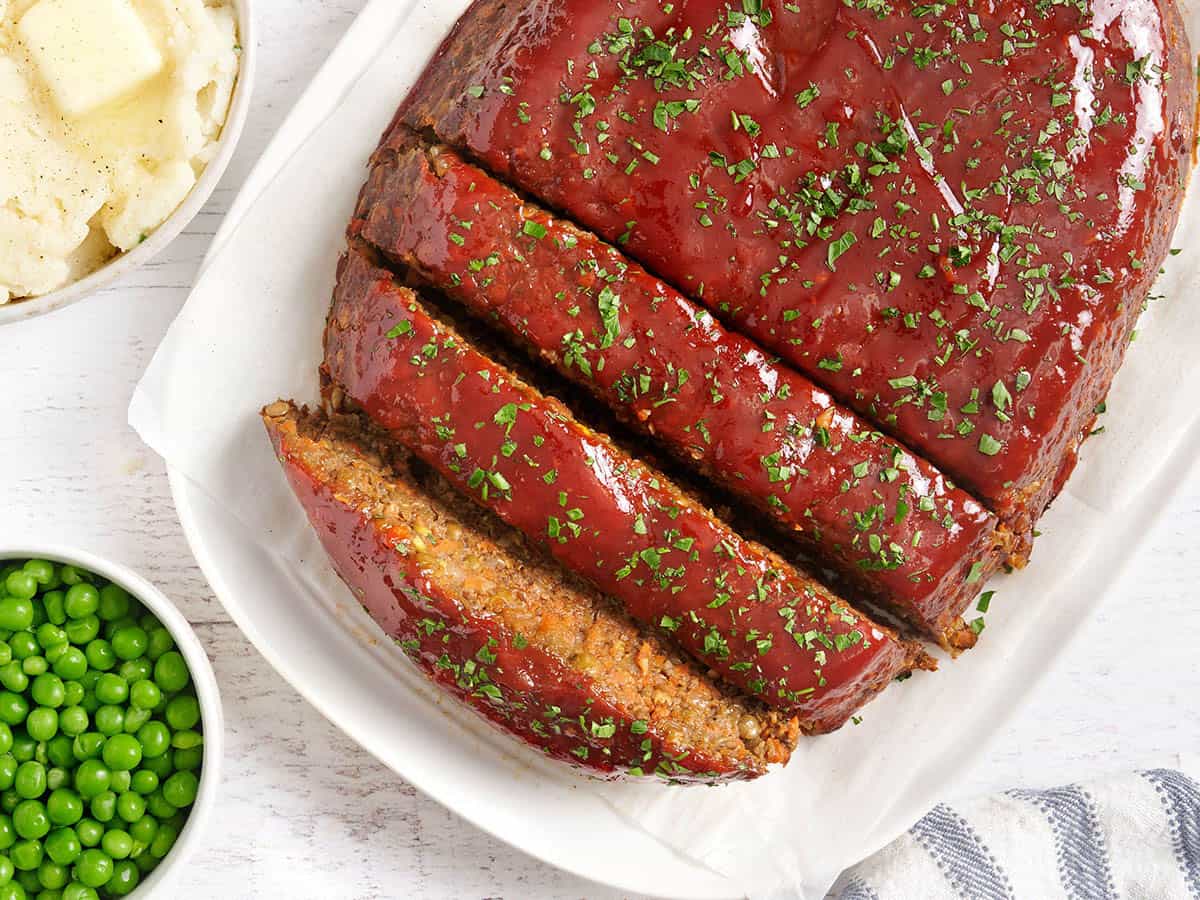 Overhead view of of a vegetarian lentil meatloaf with half cut into slices.