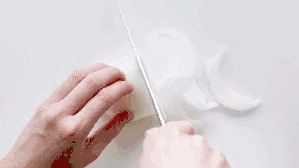 hand slicing eggplant, squash, zucchini, and tomatoes for ratatouille